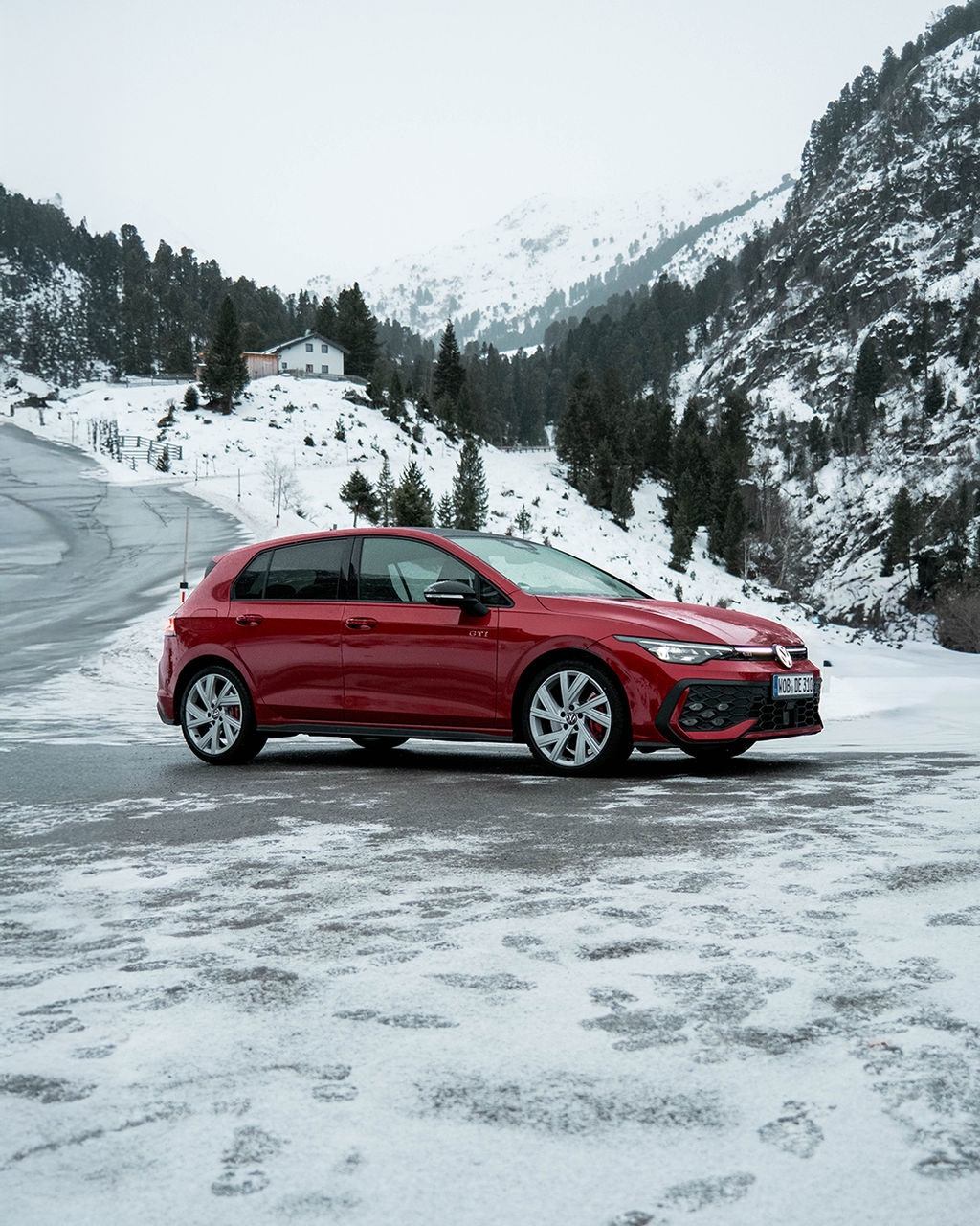 VW Golf GTI in den Bergen mit Schnee.