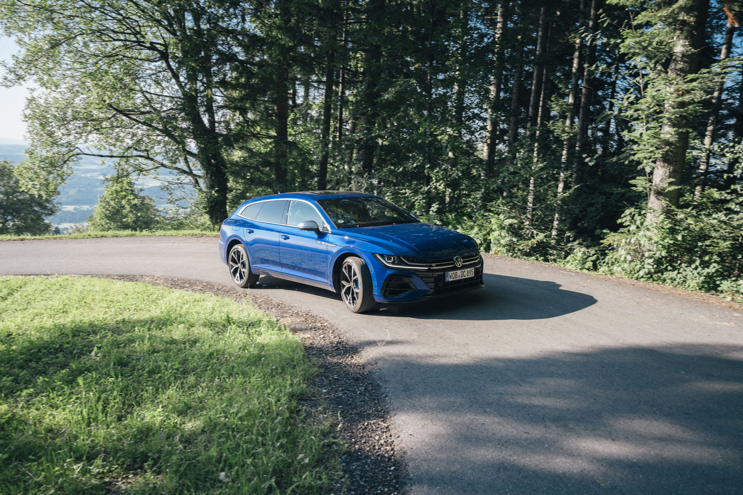 VW ARteon in einer Kurve im Wald.